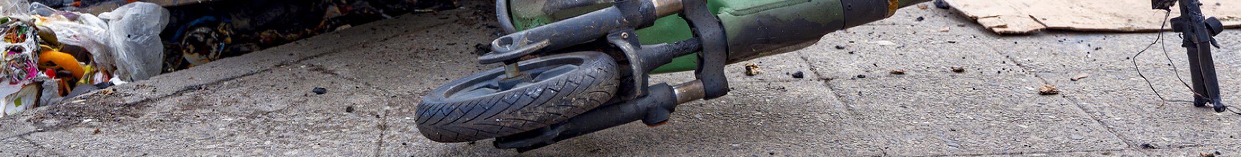 Remains of an e-scooter and rubbish on New Year's Day following vandalism and arson.